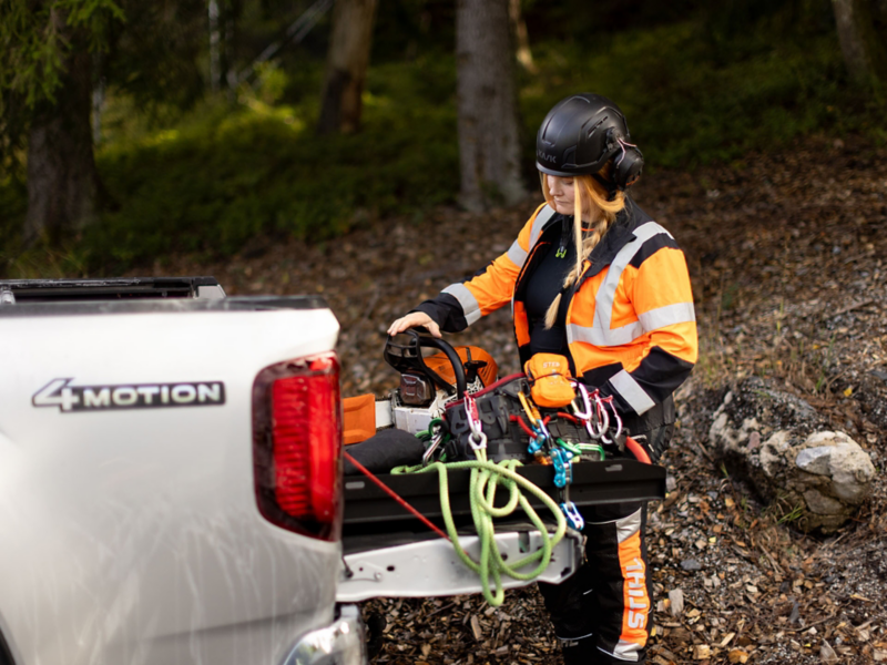 Arboristen Victoria Carstens förbereder sin motorsåg vid en VW Amarok