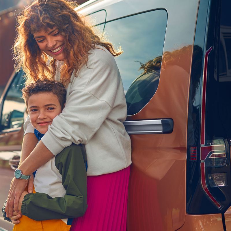 Kvinna och barn vid en Caddy Personbil familjebil