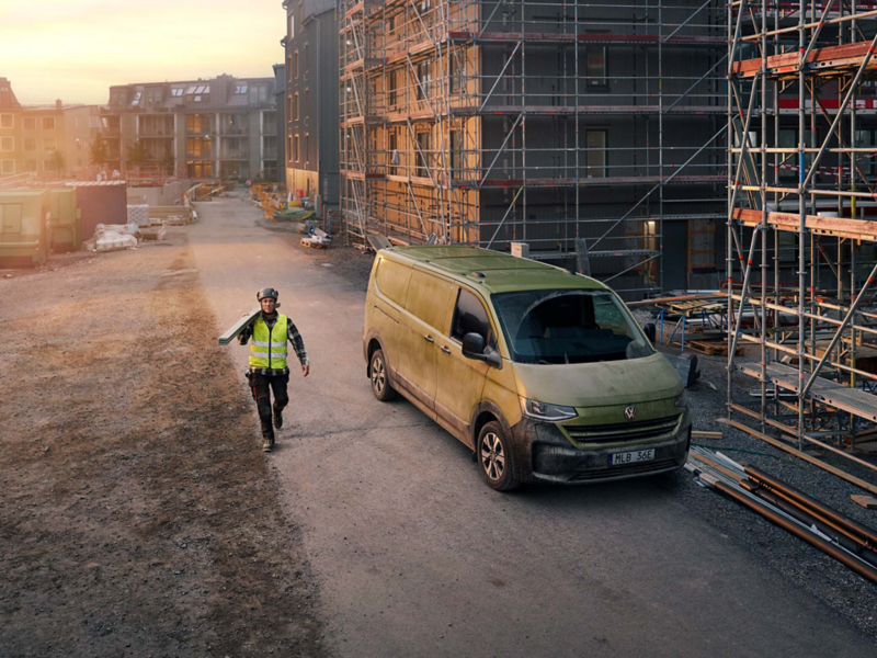 Snickaren Emil står bredvid en VW Transporter en tidig morgon