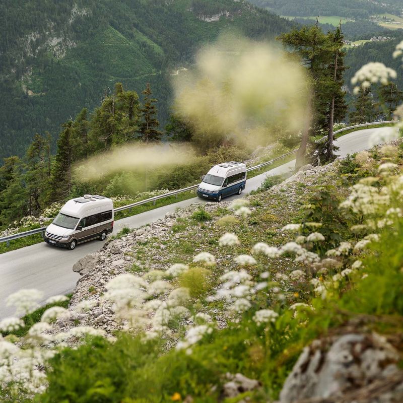VW Grand California kör längs en landsväg i bergsmiljö