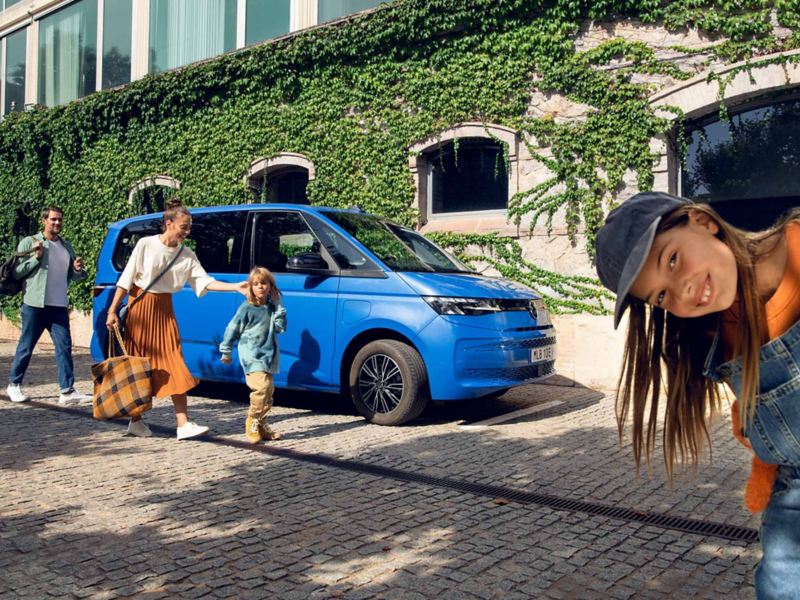 Familj vid en blå VW Multivan eHybrid