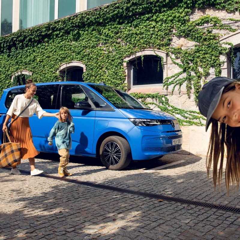 Familj vid en blå VW Multivan eHybrid minibuss