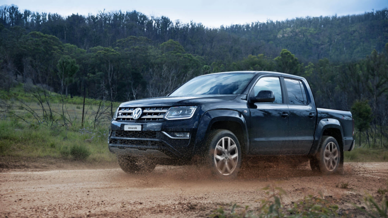 Camioneta tipo pick-up negra Amarok en camino de terracería