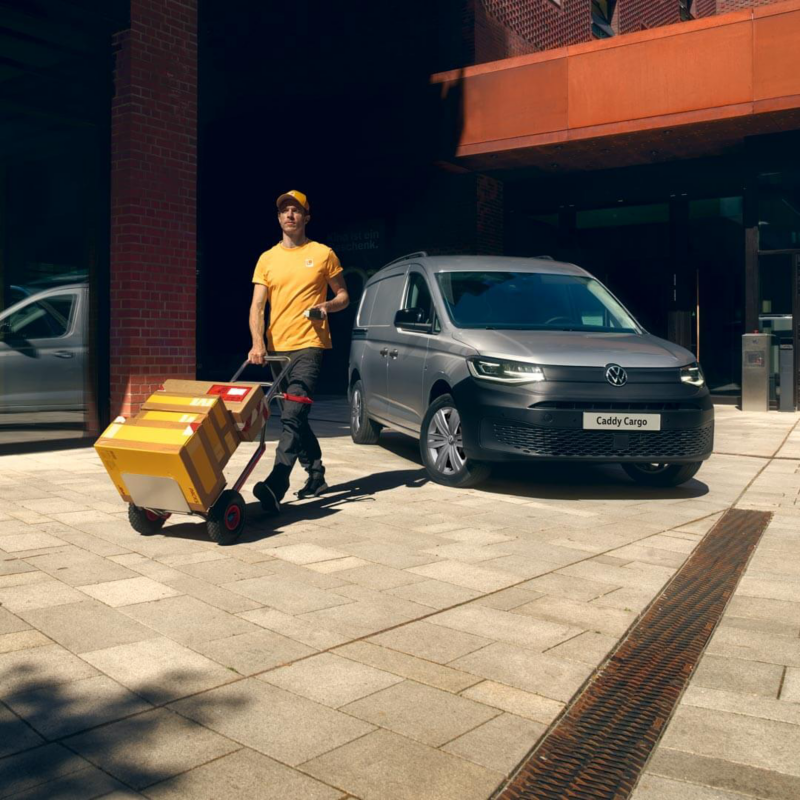 Repartidor entregando paquetes en un Caddy Cargo