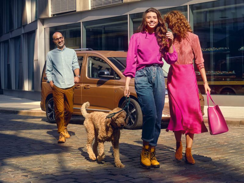 Familia haciendo compras con un vehículo familiar VW Caddy en el fondo