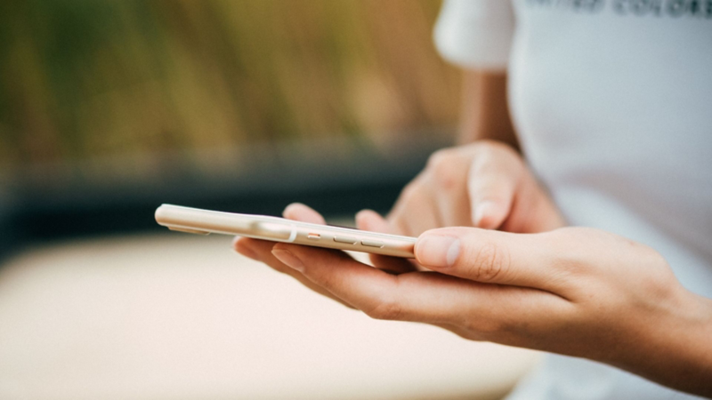 Imagen de mujer sosteniendo un teléfono celular mientras consulta Virtual Studio de Volkswagen. 