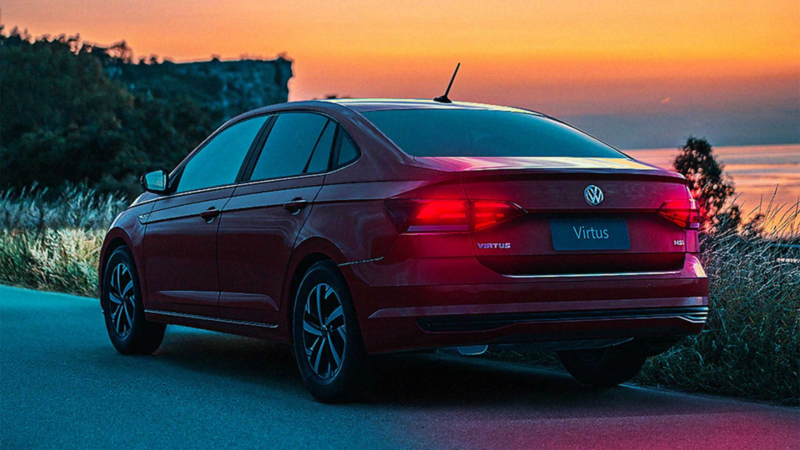 Sedán Volkswagen Virtus 2022. Auto en color rojo en un atardecer. 