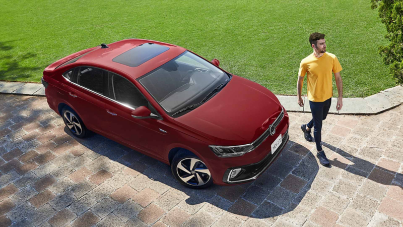 Virtus 2026, versión Highline. Modelo de sedán en color rojo, con joven conductor. 