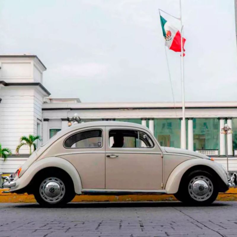 Vocho de Volkswagen en color beige transita en una calle del puerto de Veracruz. 