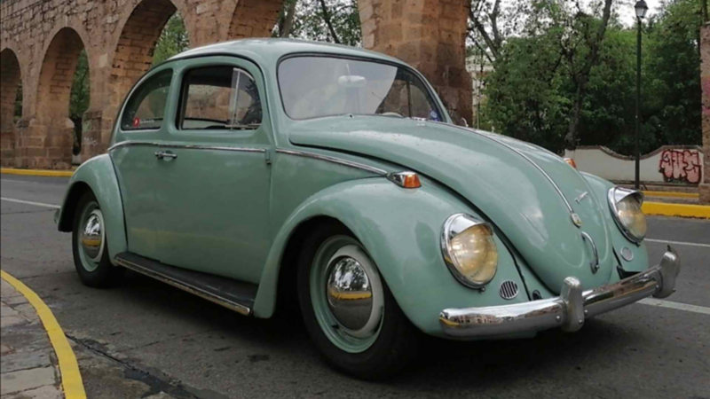 Vocho color verde turquesa cerca del acueducto de Morelia. 