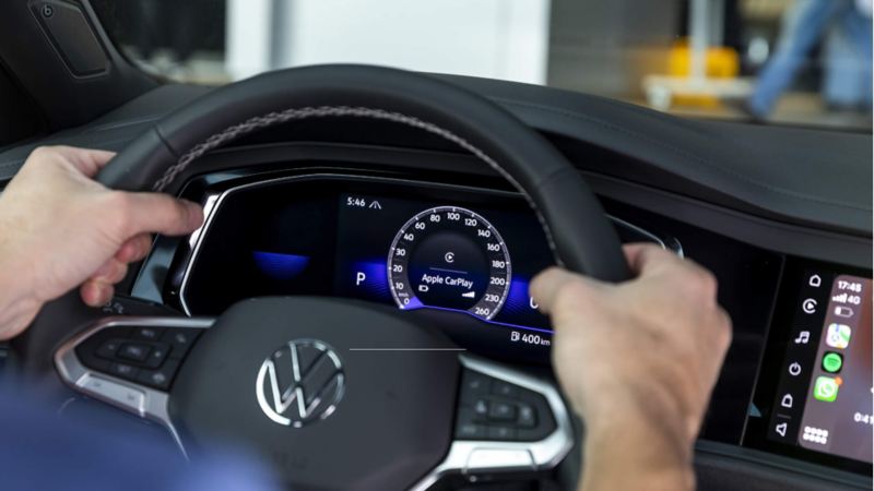 Conductor toma volante multifunciones de un auto Volkswagen.
