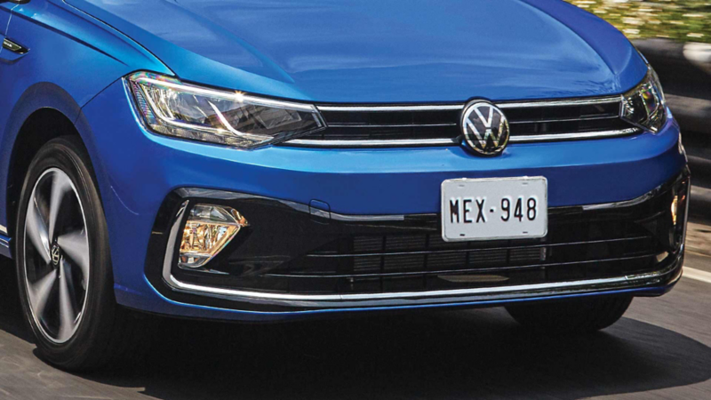 Virtus 2026 en color azul, con joven conductor a punto de abordar el auto sedán de Volkswagen. 