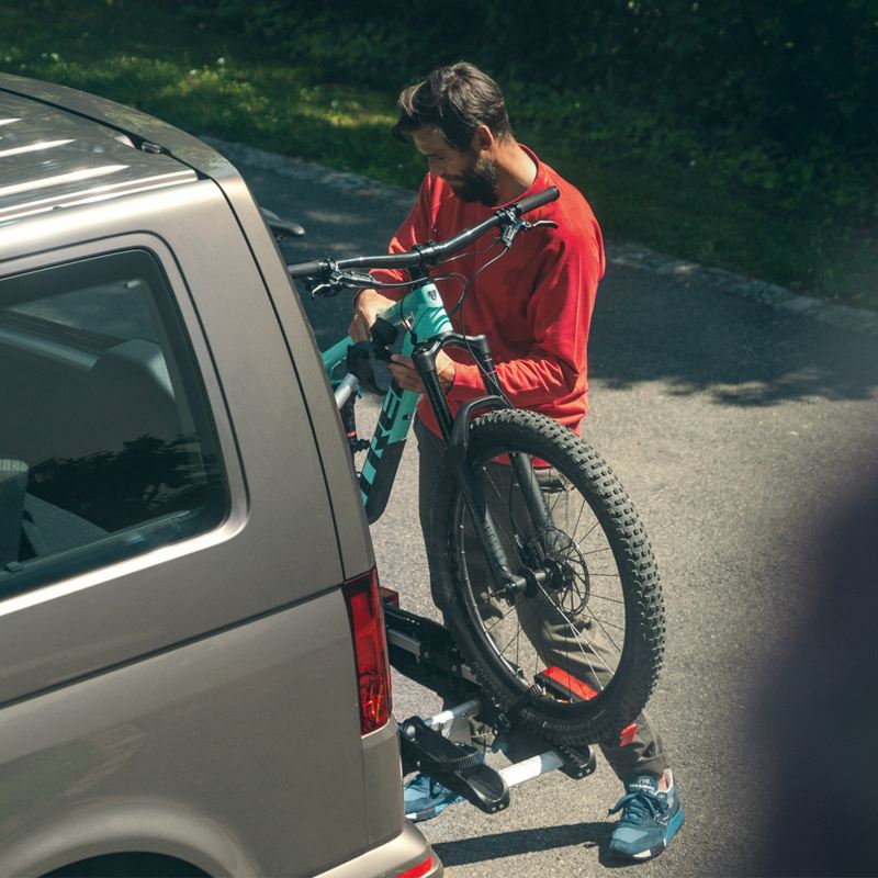 Mann hängt sein Fahrrad am Fahrradträger auf