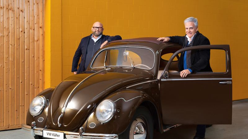 Claude Gregorini und Dino Graf stehen neben einem alten VW Käfer