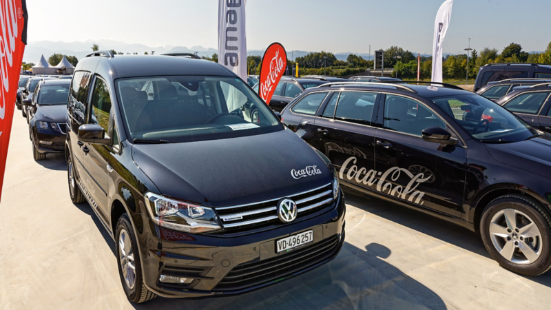 Caddy mit Coca-Cola Logo steht auf einen Parkplatz