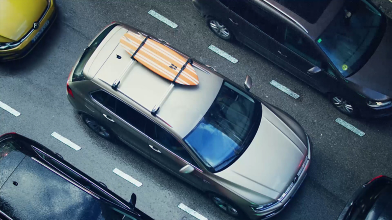 Ein Volkswagen mit einem Surfbrett auf dem Dachträger