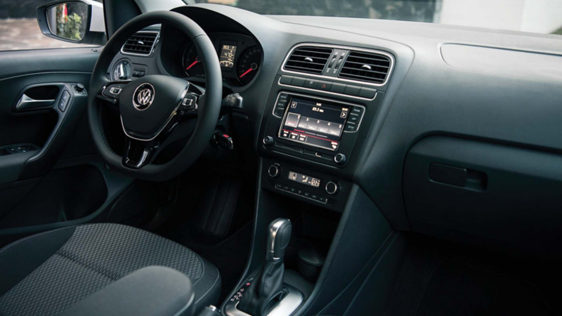 Interior de auto seminuevo Volkswagen. Volante, palanca y panel central con ventilas de aire acondicionado. 