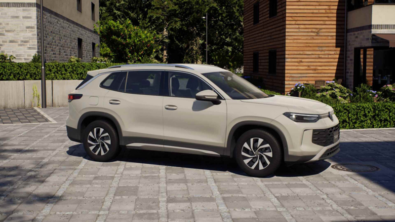Volkswagen Tiguan. Vista lateral de SUV familiar en tonalidad beige sobre calle empedrada.