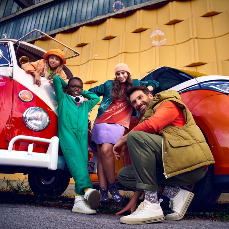 Eine Familie entspannt vor einem VW Bus.