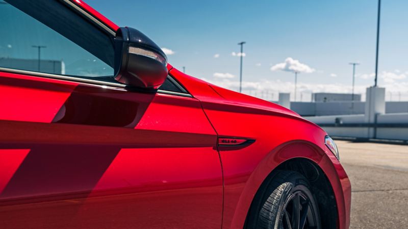 A close-up of a red Jetta GLI parked on a road