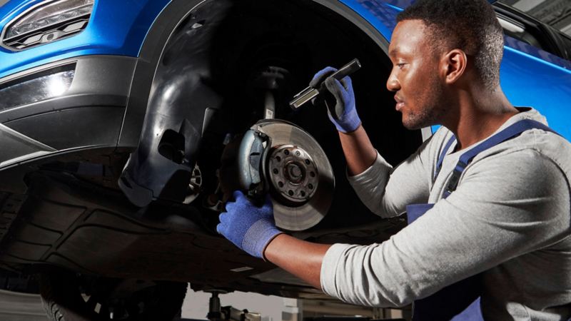 A technician checking the brake pads of a Volkswagen.