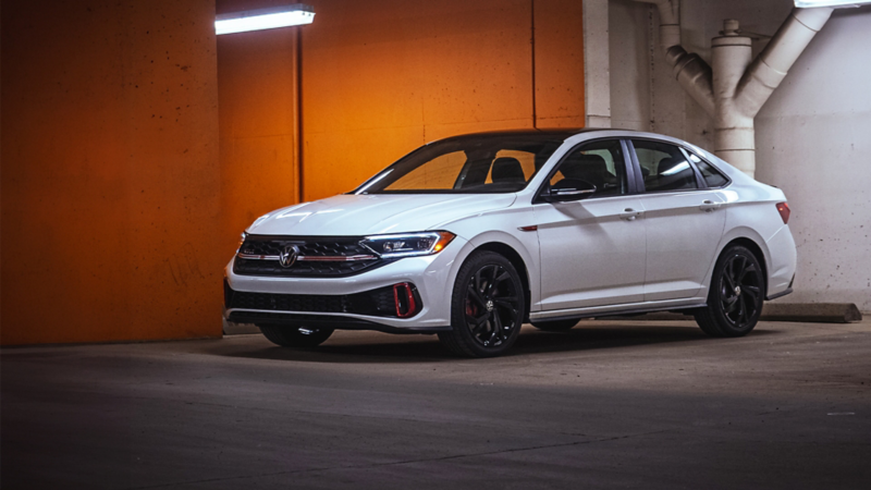 A white Jetta GLI parked in an underground parking lot