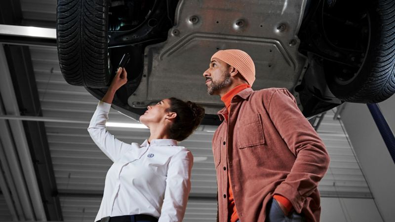 An owner is watching a technician checking a VW