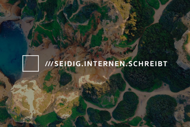 Vogelperspektive auf eine idyllische Naturlandschaft mit viel Grün und einem Gewässer. Ein eingeblendetes Quadrat markiert den genauen Standort mit der what3words-Adresse ///seidig.internen.schreibt