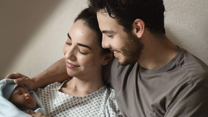 Pareja de jóvenes con bebé recién nacido.