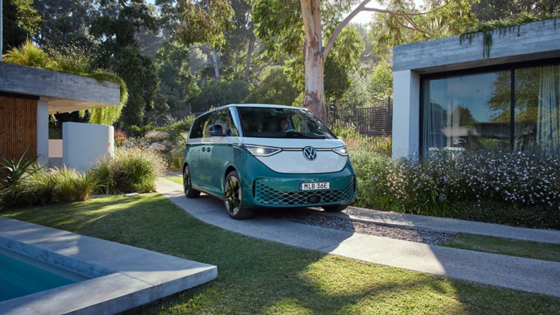 En grön-vit VW ID. Buzz Pro står på en innergård