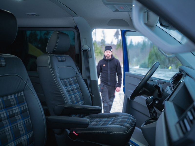 Specialinredd VW Transporter transportbil med en man i bakgrunden