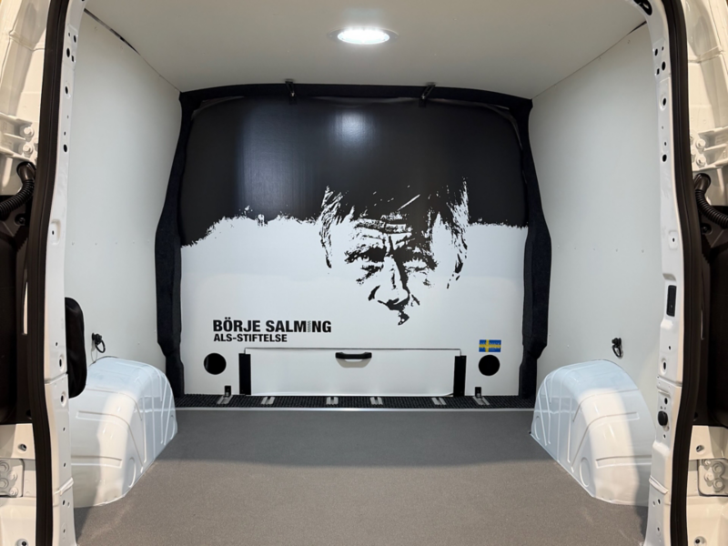 Mellanvägg sedd från lastutrymmet i en Transporter Twin Cabin Salming Edition. Väggen har ett Börje Salming-motiv