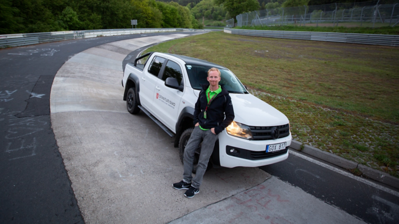 Jame Holm står vid sin vita VW Amarok generation 1 vid Nürnburgring