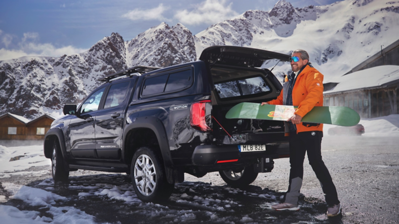 En man med snowboard lastar sin VW Amarok PanAmericana