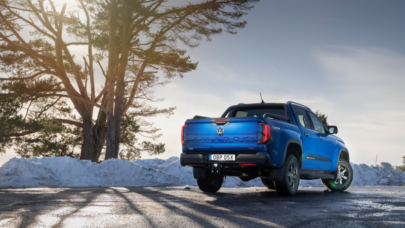 En VW Amarok Aventura står parkerad vid ett grustag. En man står bredvid.