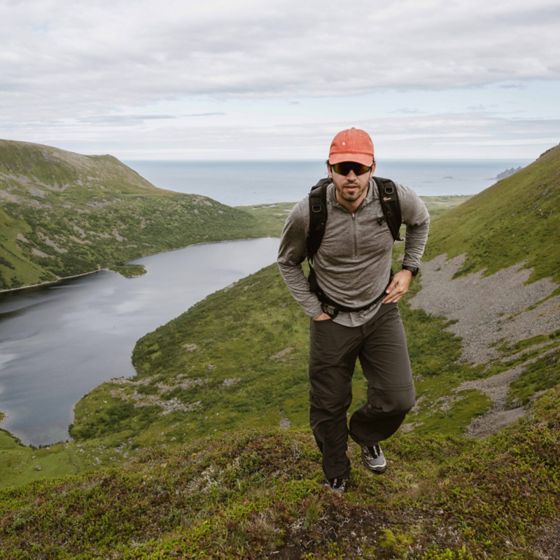 Kid Franzén vandrar i bergen vid Lofoten med utsikt över havet och en bukt
