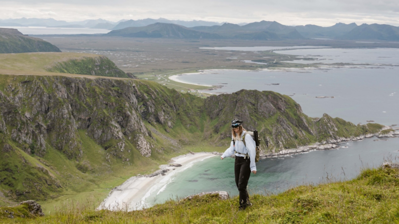 Astrid vandrar i bergen i Norge med utsikt över hav och berg