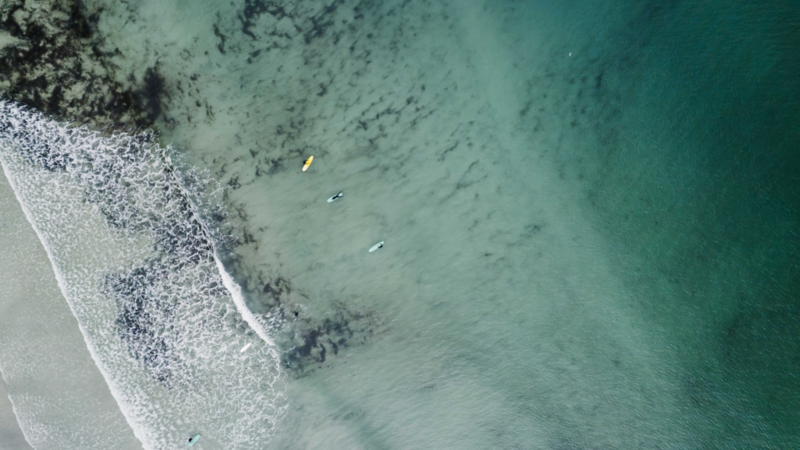 Drönarbild över surfare i vattnet vid Lofoten i Norge