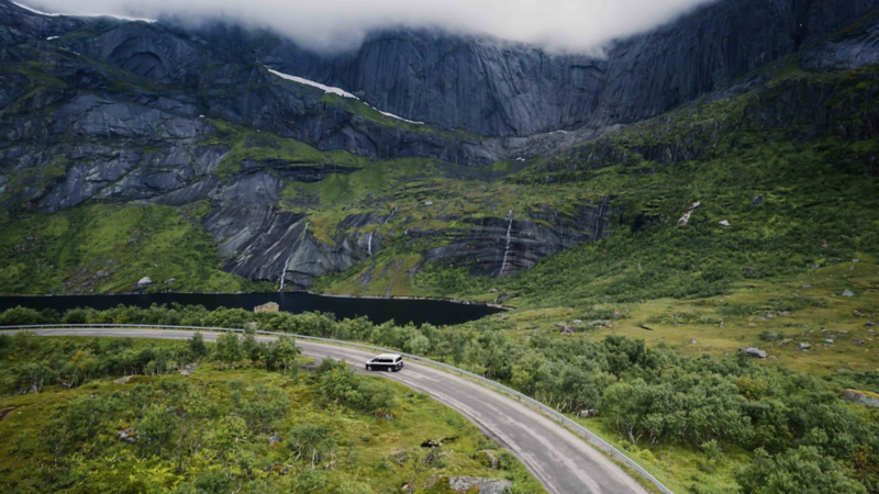 En VW California campingbil kör på en landsväg i Norge