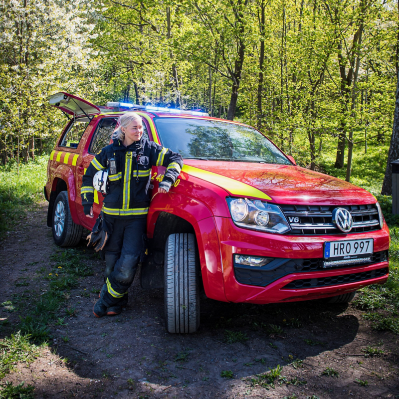 Närbild på brandmannen Elna som står framför sin röda VW Amarok