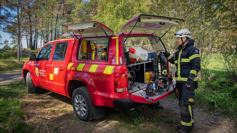 Brandmannen Elna står bakom en röd VW Amarok med kåpan öppen