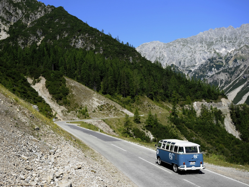 Vitblå VW T1 Samba kör i alperna