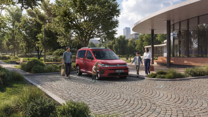 En familj står runt en röd VW Caddy Personbil