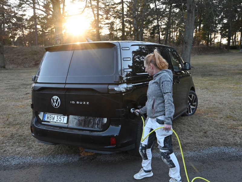 Målaren Mona Espig sätter i laddkabeln i en VW ID. Buzz Cargo