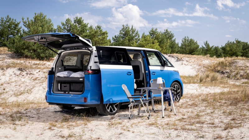ID. California Cruise står parkerad vid en strand med campingbord och campingstolar