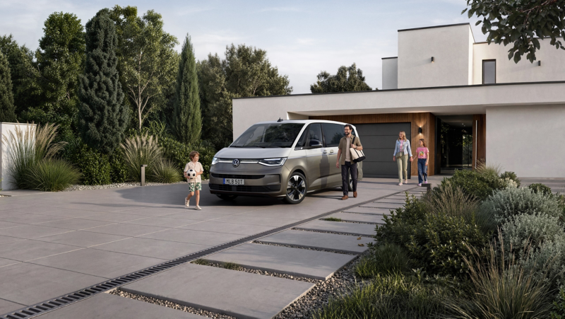 Minibussen VW Multivan står parkerad på en garageuppfart