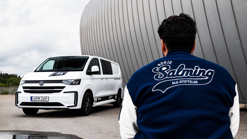 En man med Salming-jacka sitter framför en Transporter Twin Cabin Salming Edition