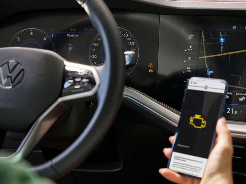 Une personne utilise son application Volkswagen pour identifier un voyant lumineux.
