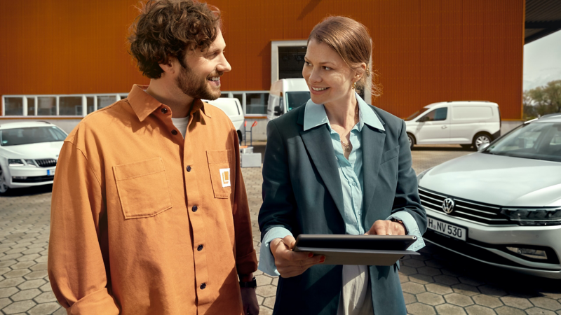 A VW Van Centre colleague talking to a customer walking past VW vans. 