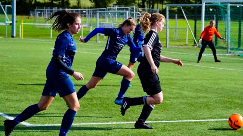 Drei Spielerinnen im Duell um den Ball